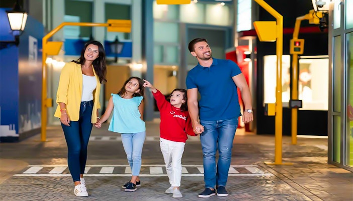 Family exploring KidZania Abu Dhabi indoor city attractions.