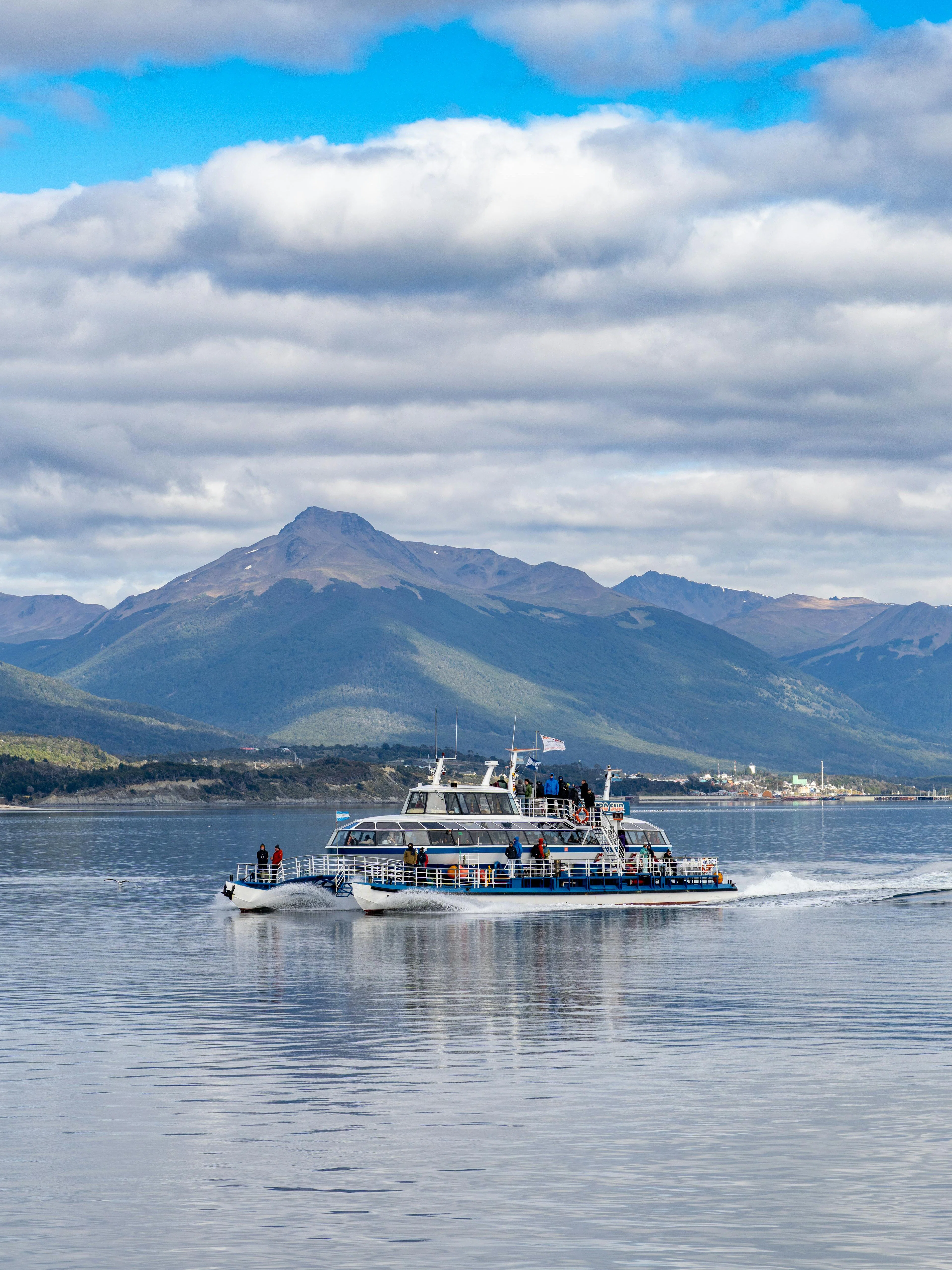 Catamaran sailing on Beagle Channel with mountains in Ushuaia, Argentina.