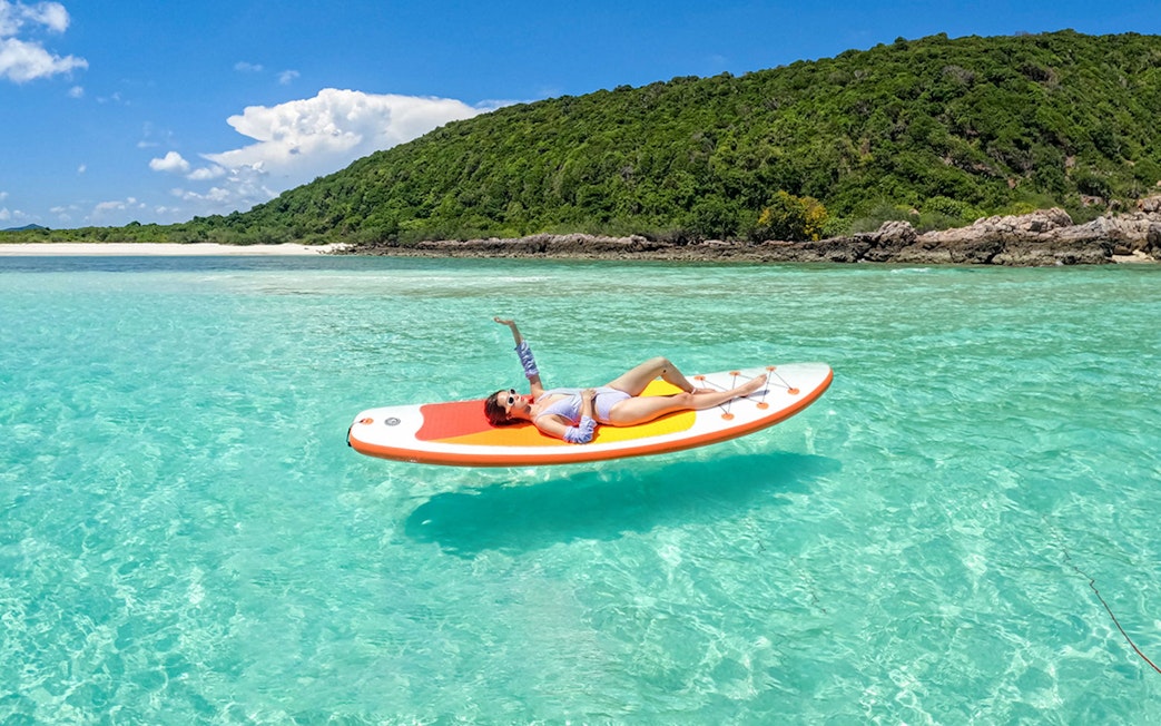Paddleboarder relaxing on clear waters near Nemo Island, Pattaya.