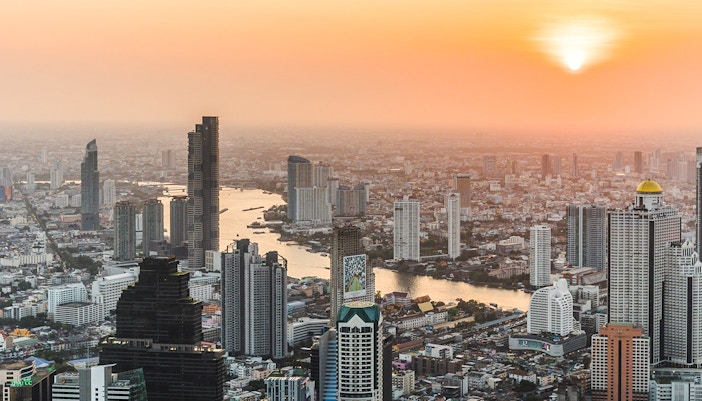 Bangkok skyline view from Mahanakhon Skywalk at sunset with Chao Phraya River.