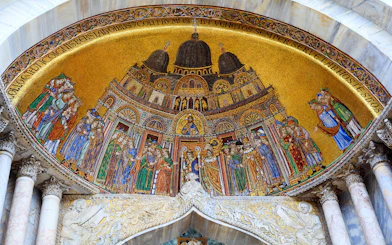 Mosaic detail of St Mark's Basilica in Venice, featuring religious figures and intricate designs.