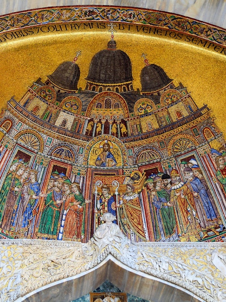 Mosaic detail of St Mark's Basilica in Venice, featuring religious figures and intricate designs.