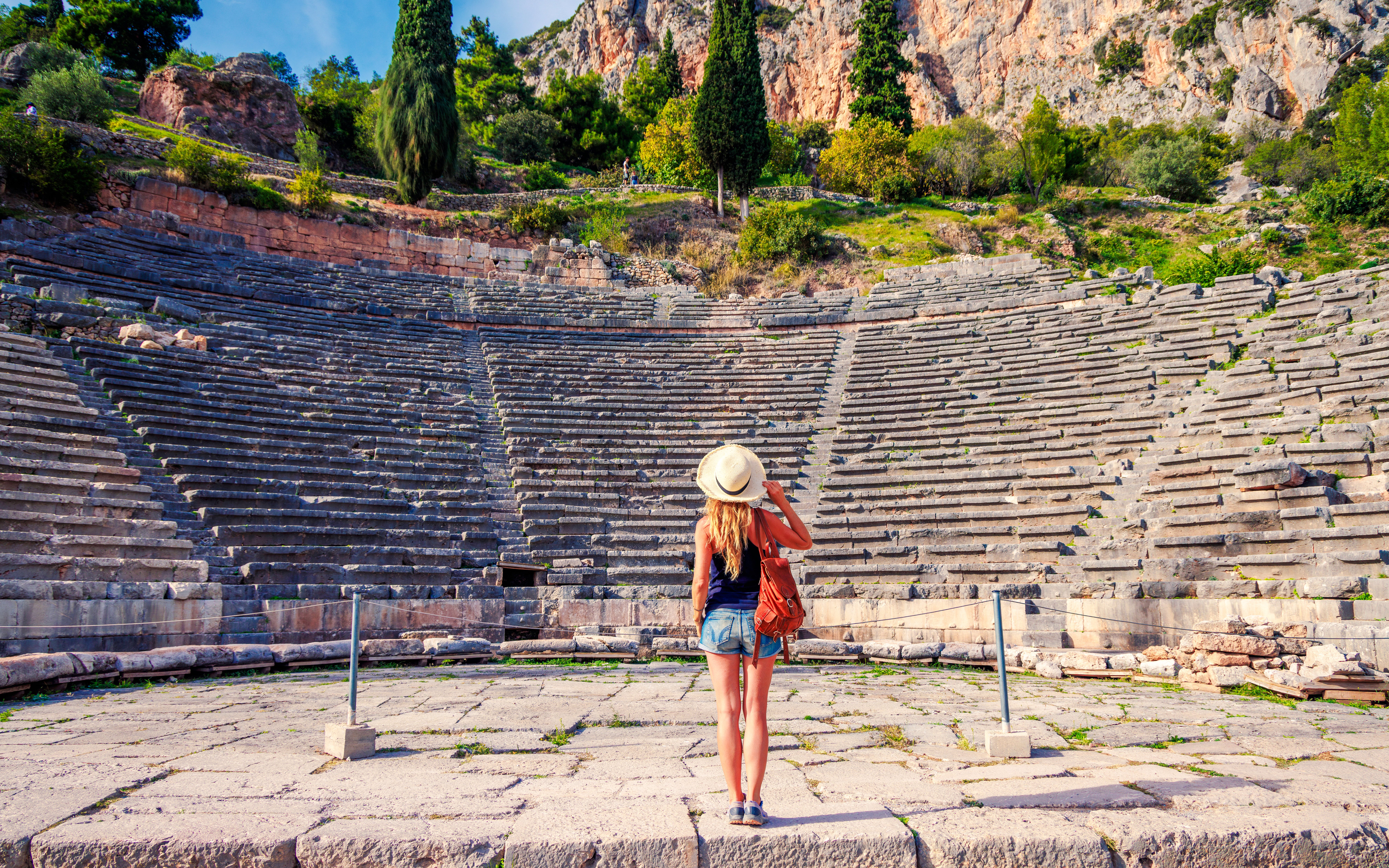Visitor exploring the ancient Theater of Delphi in Greece.