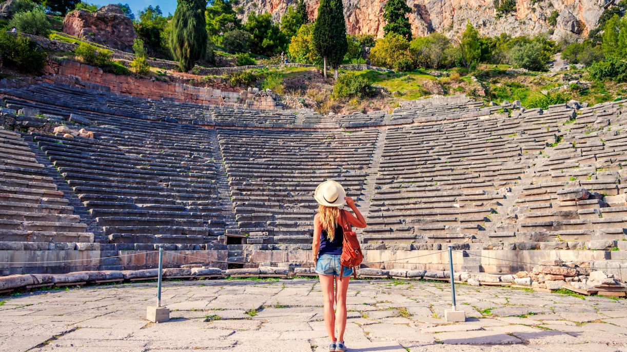 Visitor exploring the ancient Theater of Delphi in Greece.