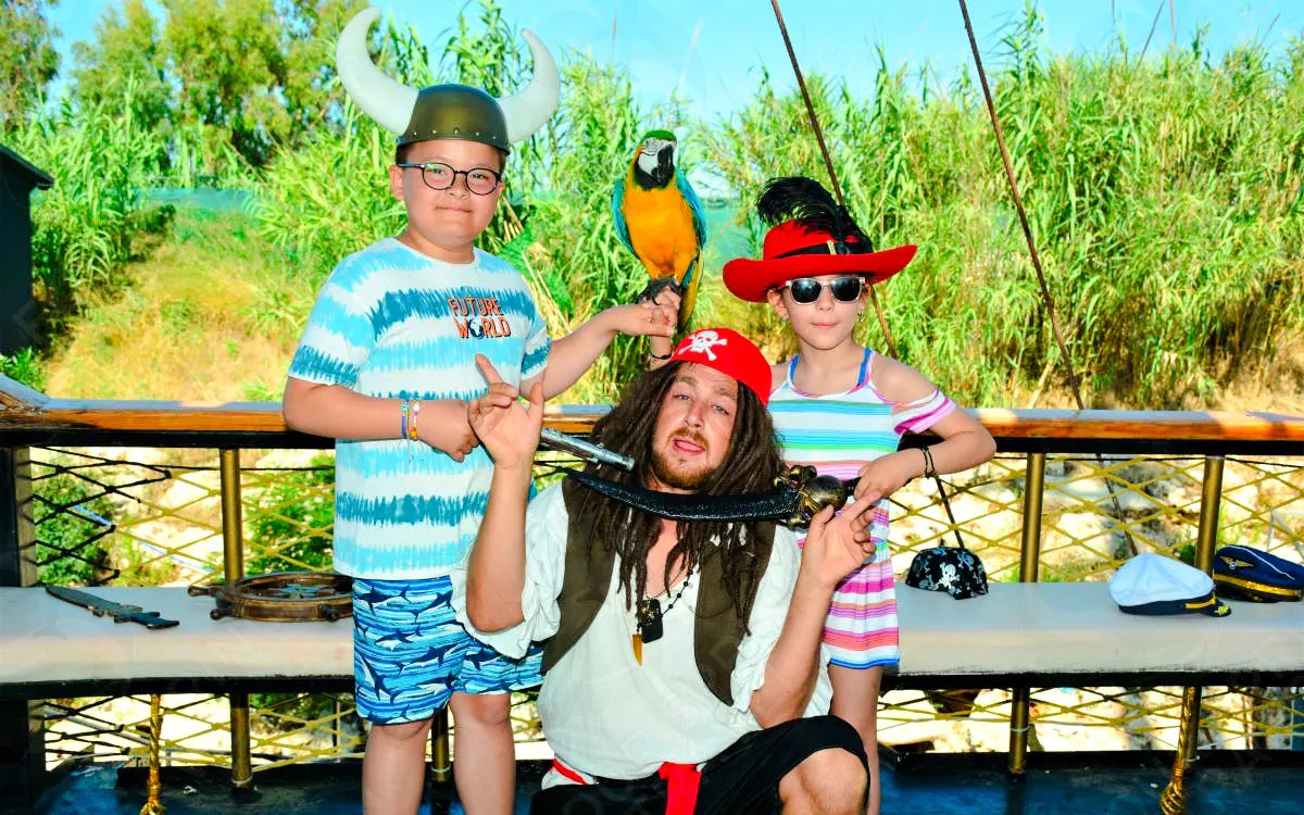 Kids with pirate and parrot on Pirate Ship Cruise in Antalya, Turkey.