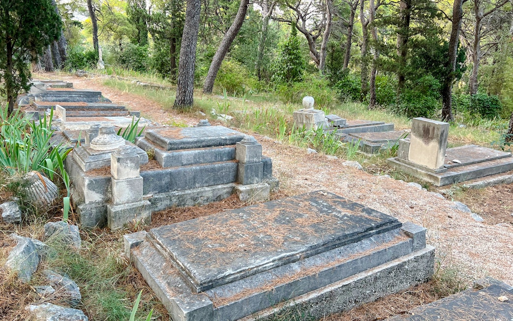 Old Jewish Cemetery in Split, Croatia with historic stone graves surrounded by trees.