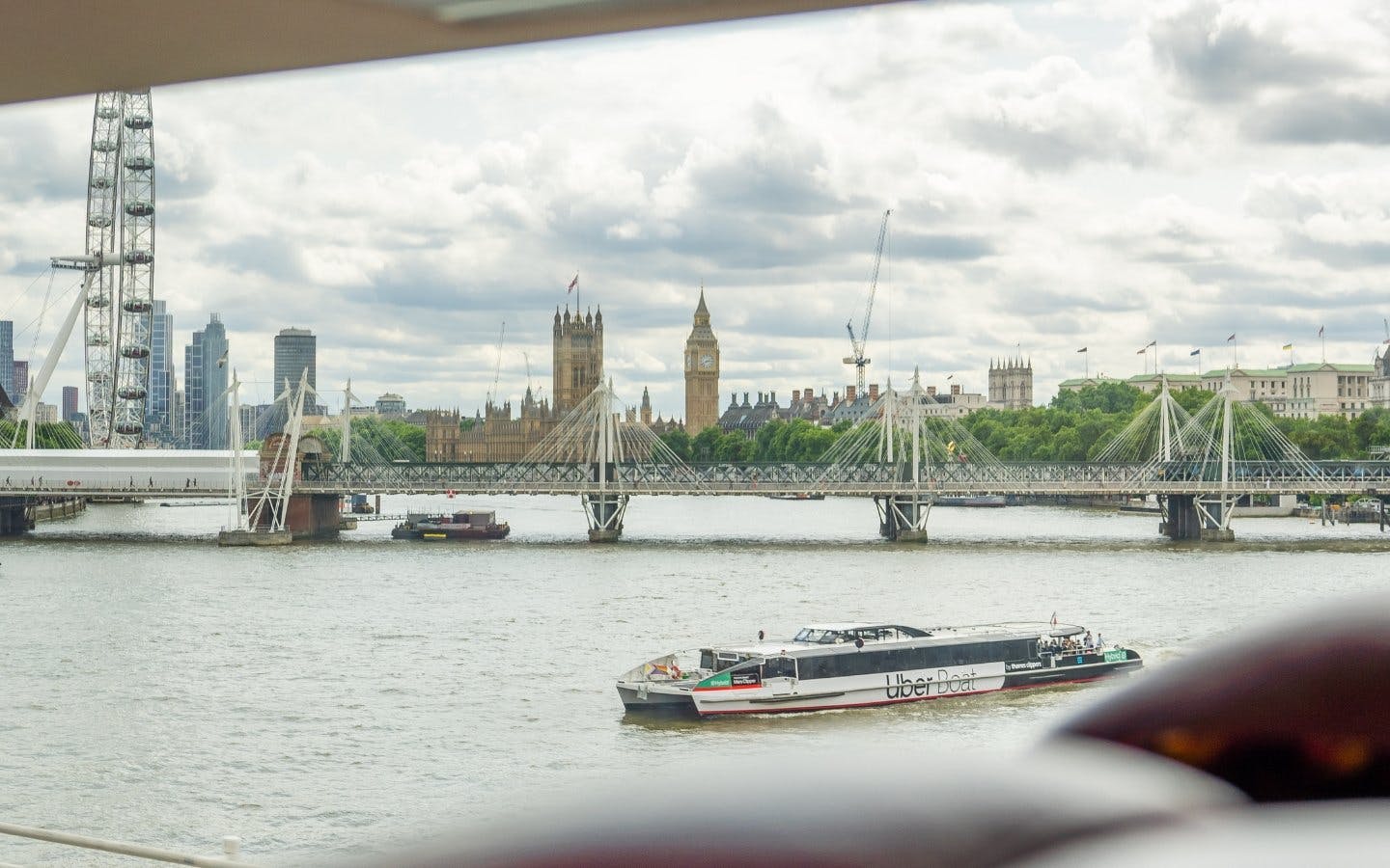London Eye and Big Ben viewed from the Thames River on a sightseeing bus tour.
