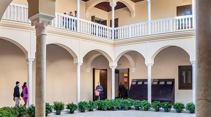 Courtyard of the Picasso Museum in Malaga with arches and potted plants.