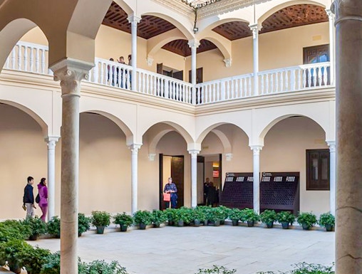 Courtyard of the Picasso Museum in Malaga with arches and potted plants.