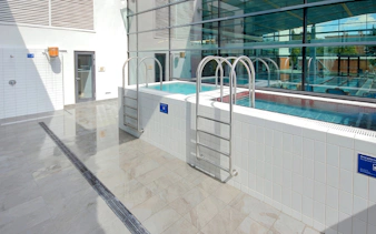 Indoor pools at Paskal Thermal Bath, Budapest with ladders and glass windows.