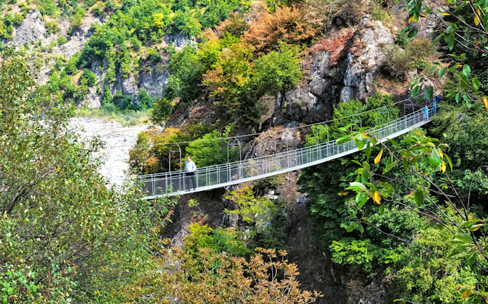 Iron hanging bridge over lush mountain landscape in Ismailli, Greater Caucasus, Azerbaijan.