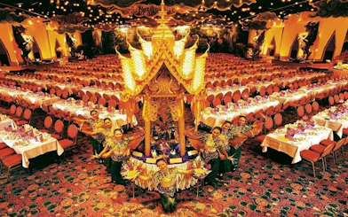 Phuket FantaSea Show dining hall with performers in traditional attire.
