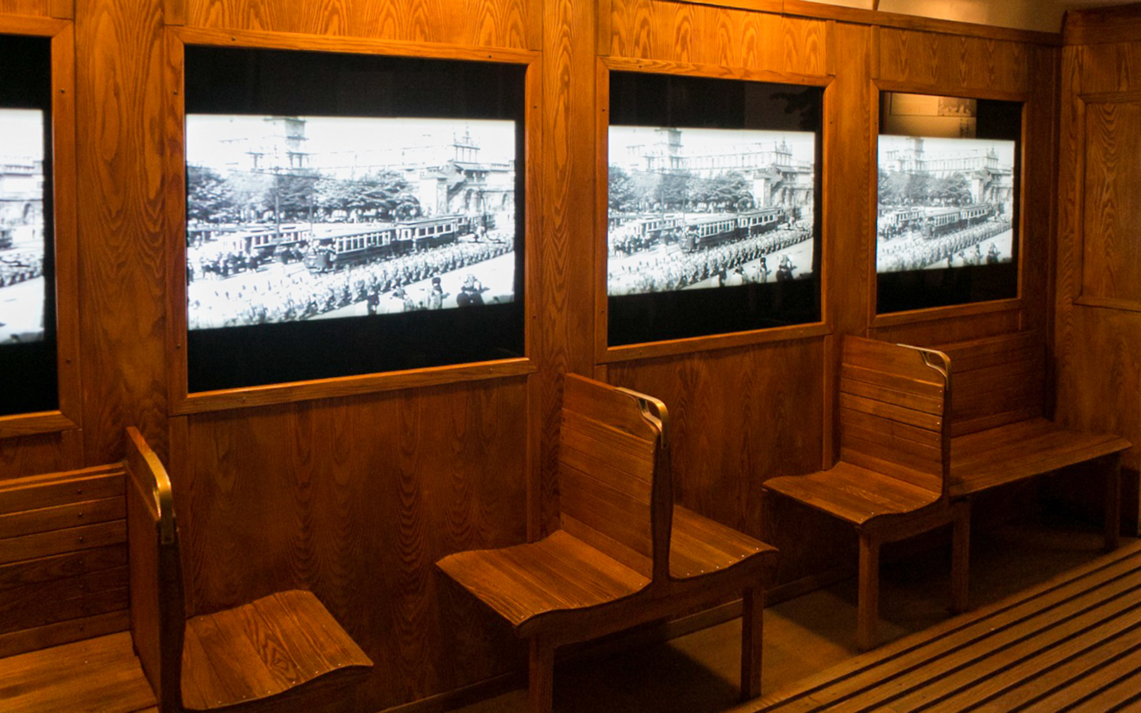 Wooden benches and historical displays at Schindler's Factory, Krakow tour.