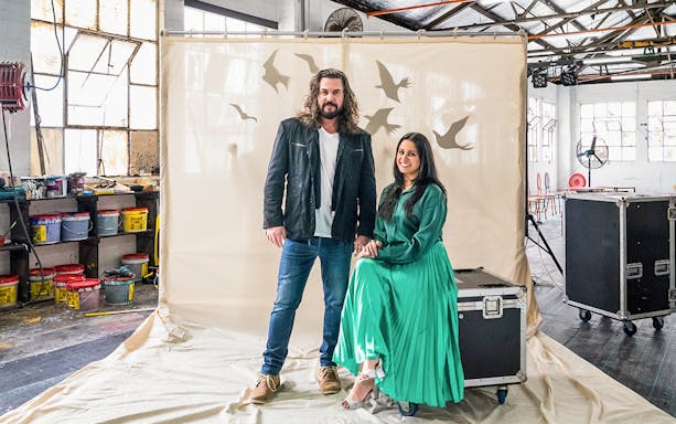 Two people in a studio setting with a backdrop of birds, related to The Magic Flute at the Sydney Opera House.