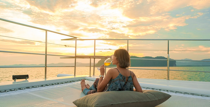 Woman enjoying sunset on yacht deck during James Bond tour from Phuket.