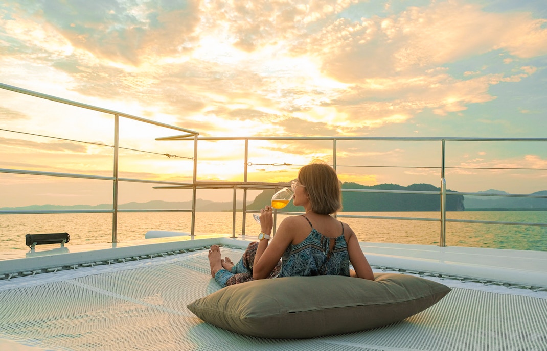 Woman enjoying sunset on yacht deck during James Bond tour from Phuket.
