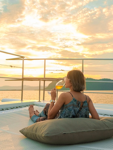 Woman enjoying sunset on yacht deck during James Bond tour from Phuket.