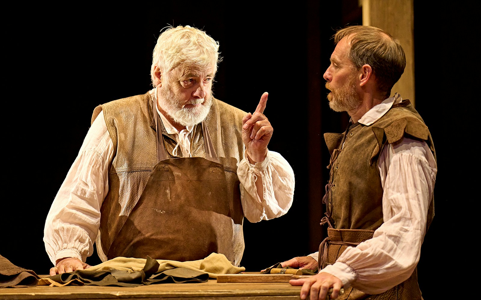 Two actors in period costumes perform a scene from the play "Hamnet" on stage.
