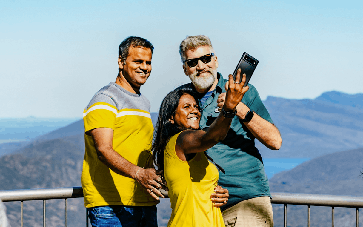 Guests taking a selfie at Boroka Lookout with mountain views in the background.
