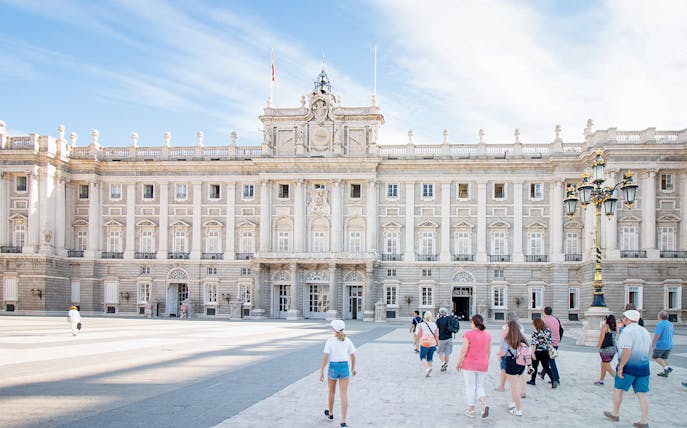 Visitors entering Madrid Royal Palace courtyard, Spain.
