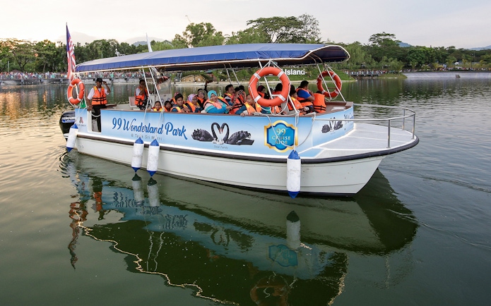 Boat tour at 99 Wonderland Park with passengers wearing life jackets.
