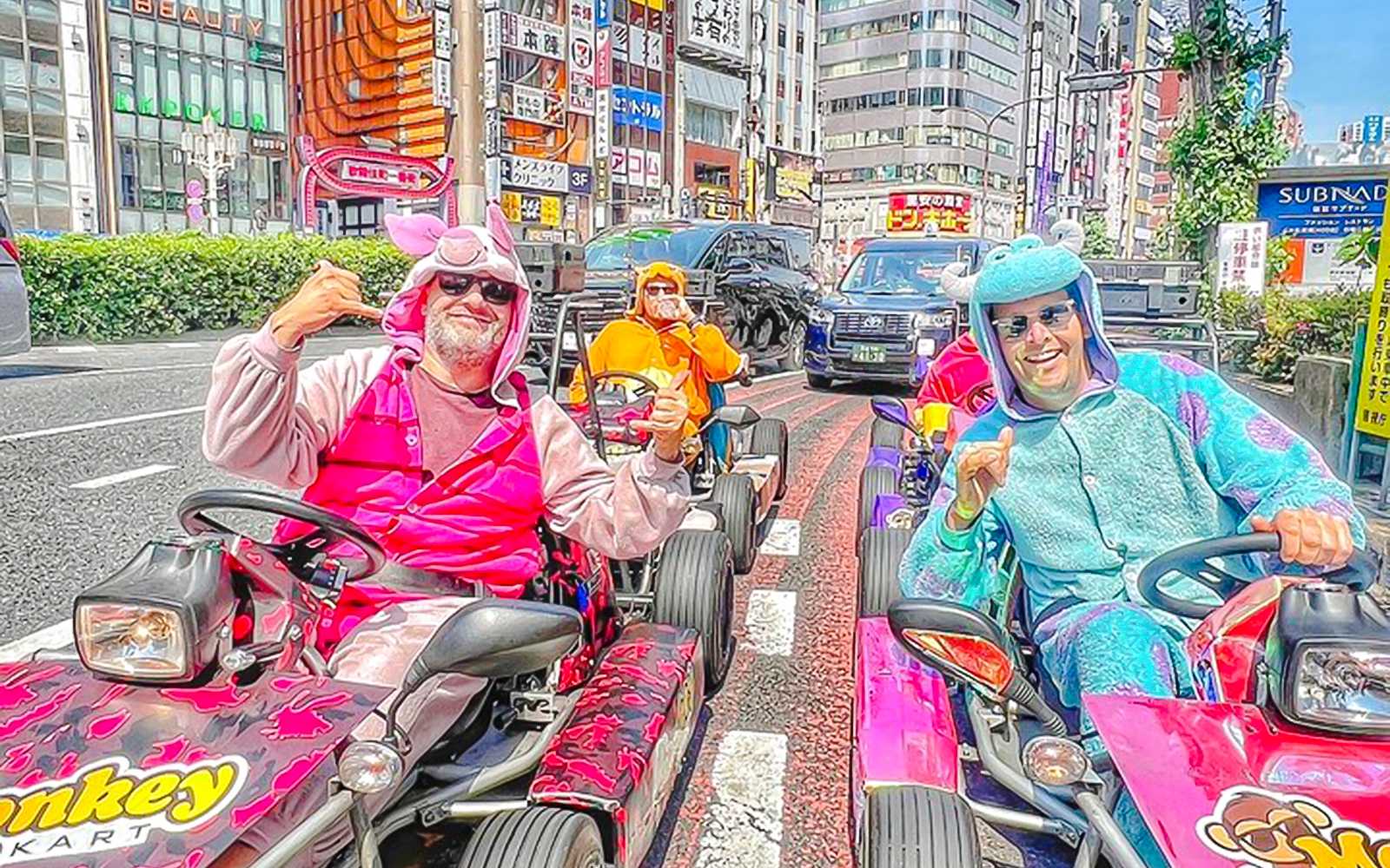Couple in costumes driving go-karts on Shibuya streets, Tokyo.