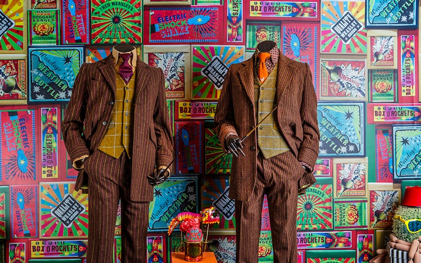 Weasley twins' suits and joke products at the magical mischief exhibit, Harry Potter London tour.