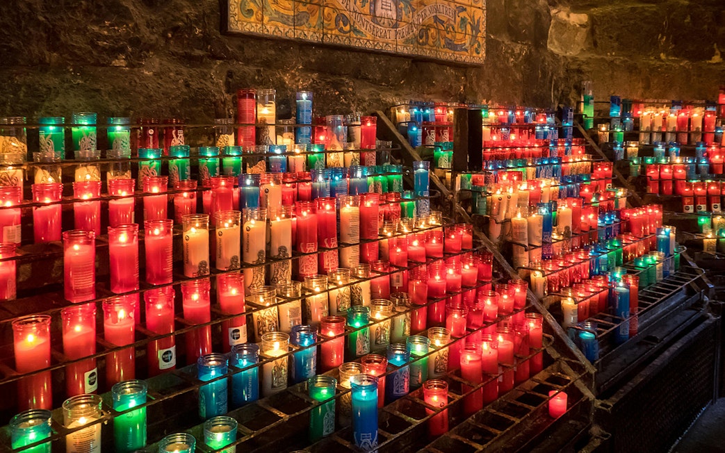 Colorful candles lit inside Montserrat Monastery, Spain.