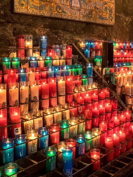 Colorful candles lit inside Montserrat Monastery, Spain.