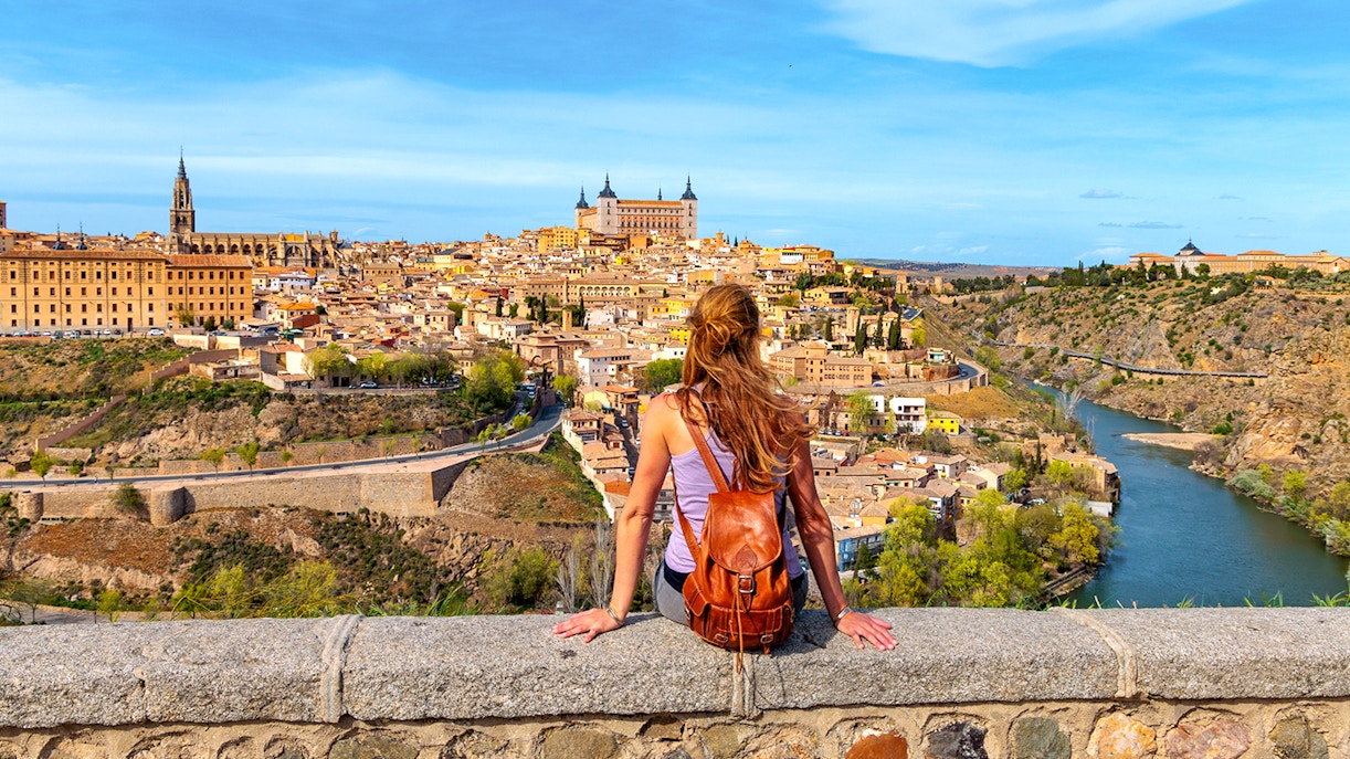 Tourist overlooking Toledo cityscape and Tagus River, Spain.