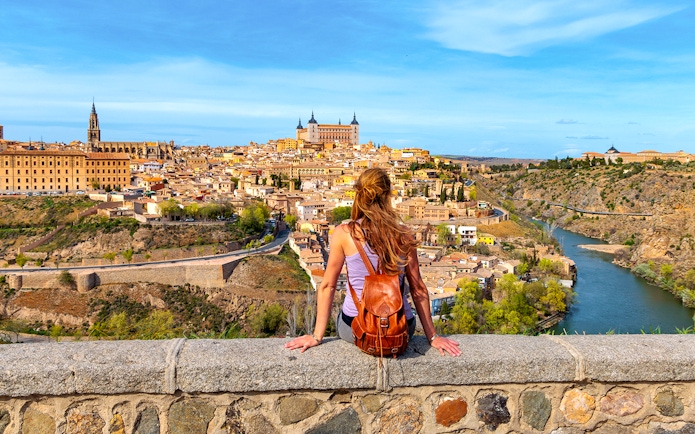 Tourist overlooking Toledo cityscape and Tagus River, Spain.