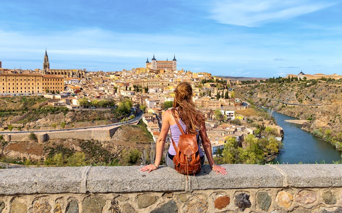 Tourist overlooking Toledo cityscape and Tagus River, Spain.