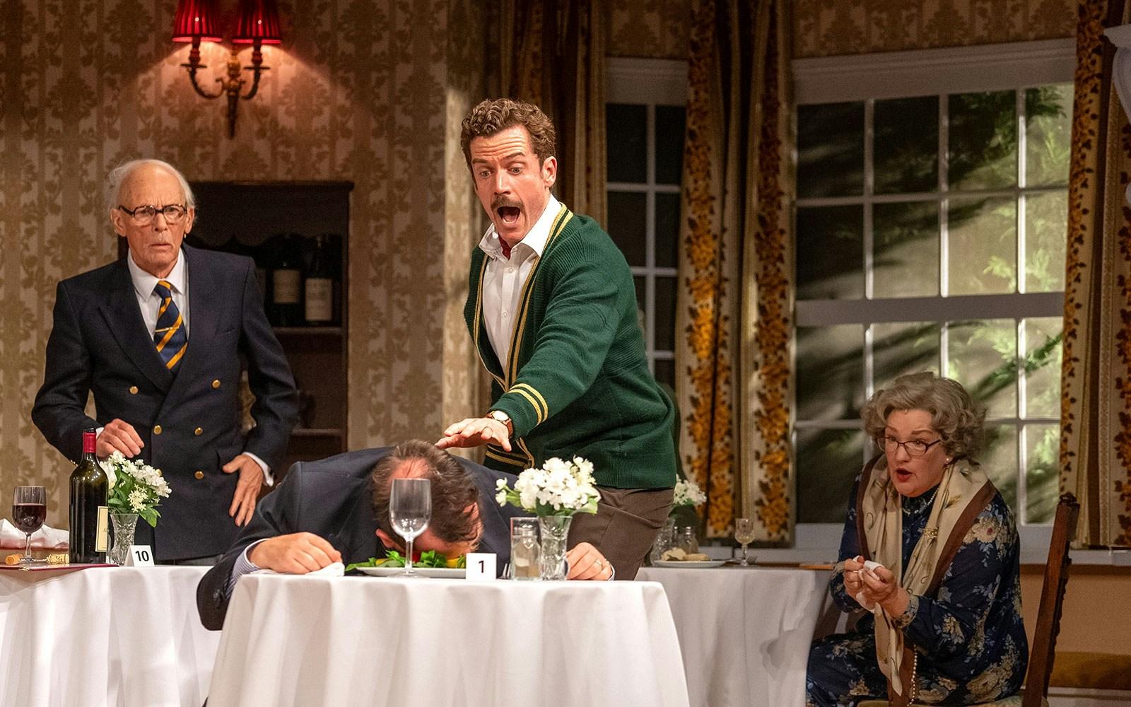 Dining scene from Fawlty Towers with guests reacting to a mishap at a restaurant table.