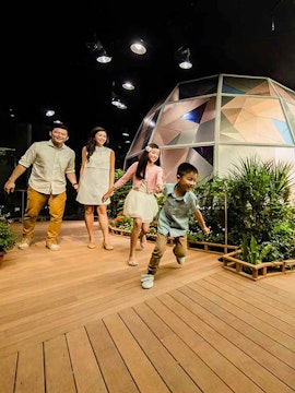 Family exploring Science Centre Observatory with geodesic dome in background.