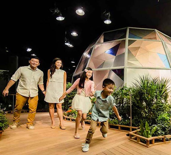 Family exploring Science Centre Observatory with geodesic dome in background.