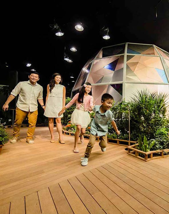 Family exploring Science Centre Observatory with geodesic dome in background.