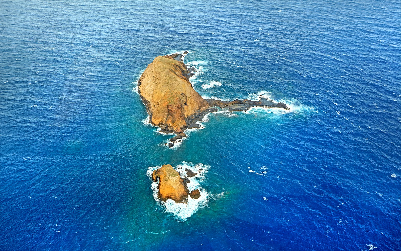 Aerial view of rocky islets surrounded by ocean during a helicopter tour in Maui and Molokai, Hawaii.
