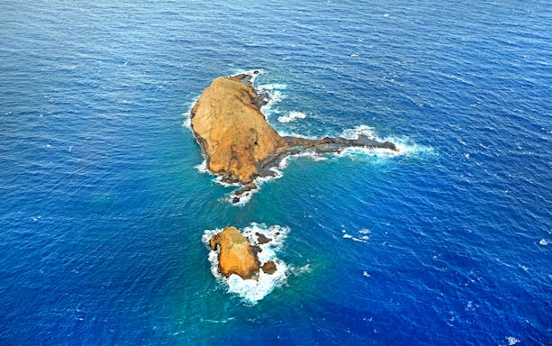 Aerial view of rocky islets surrounded by ocean during a helicopter tour in Maui and Molokai, Hawaii.