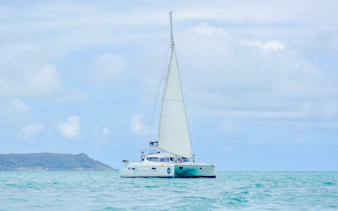 Catamaran sailing towards Ile aux Cerf for parasailing and tube riding adventure.