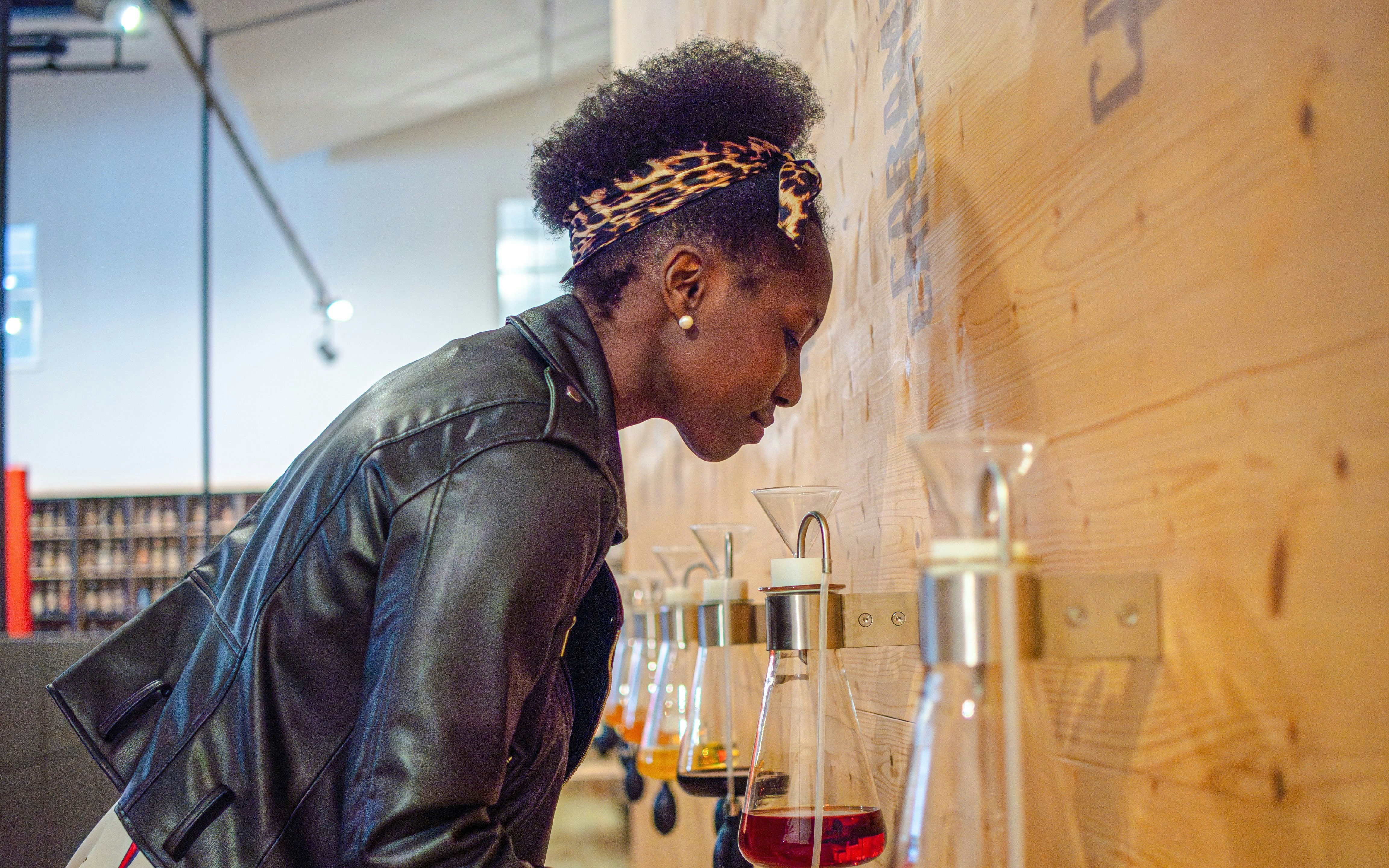 Visitor smelling perfume samples at Fragonard Perfume Museum in Paris.