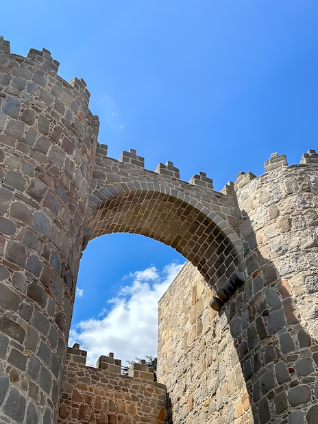 Alcazar gate at Avila Wall under a clear blue sky in Spain.