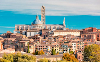 Siena Cathedral exterior with bell tower and surrounding historic buildings.
