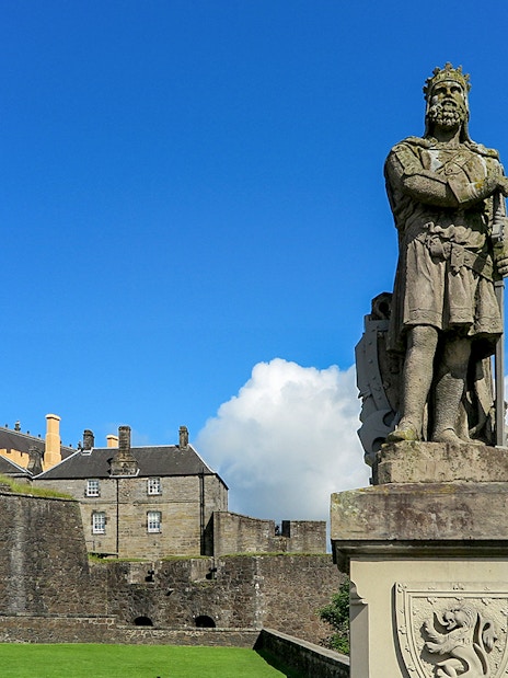 Statue at Stirling Castle with historic buildings in the background, Scotland.