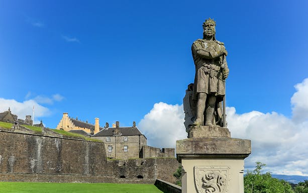 Statue at Stirling Castle with historic buildings in the background, Scotland.