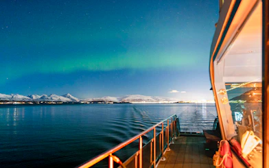Cruise ship deck under Northern Lights near Tromso, Norway.