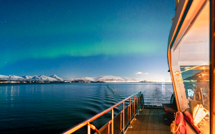 Cruise ship deck under Northern Lights near Tromso, Norway.
