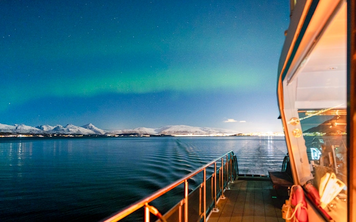 Cruise ship deck under Northern Lights near Tromso, Norway.