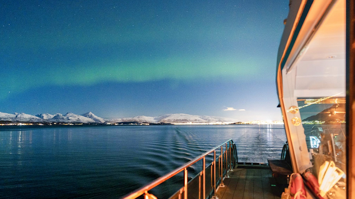 Cruise ship deck under Northern Lights near Tromso, Norway.