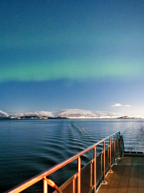 Cruise ship deck under Northern Lights near Tromso, Norway.