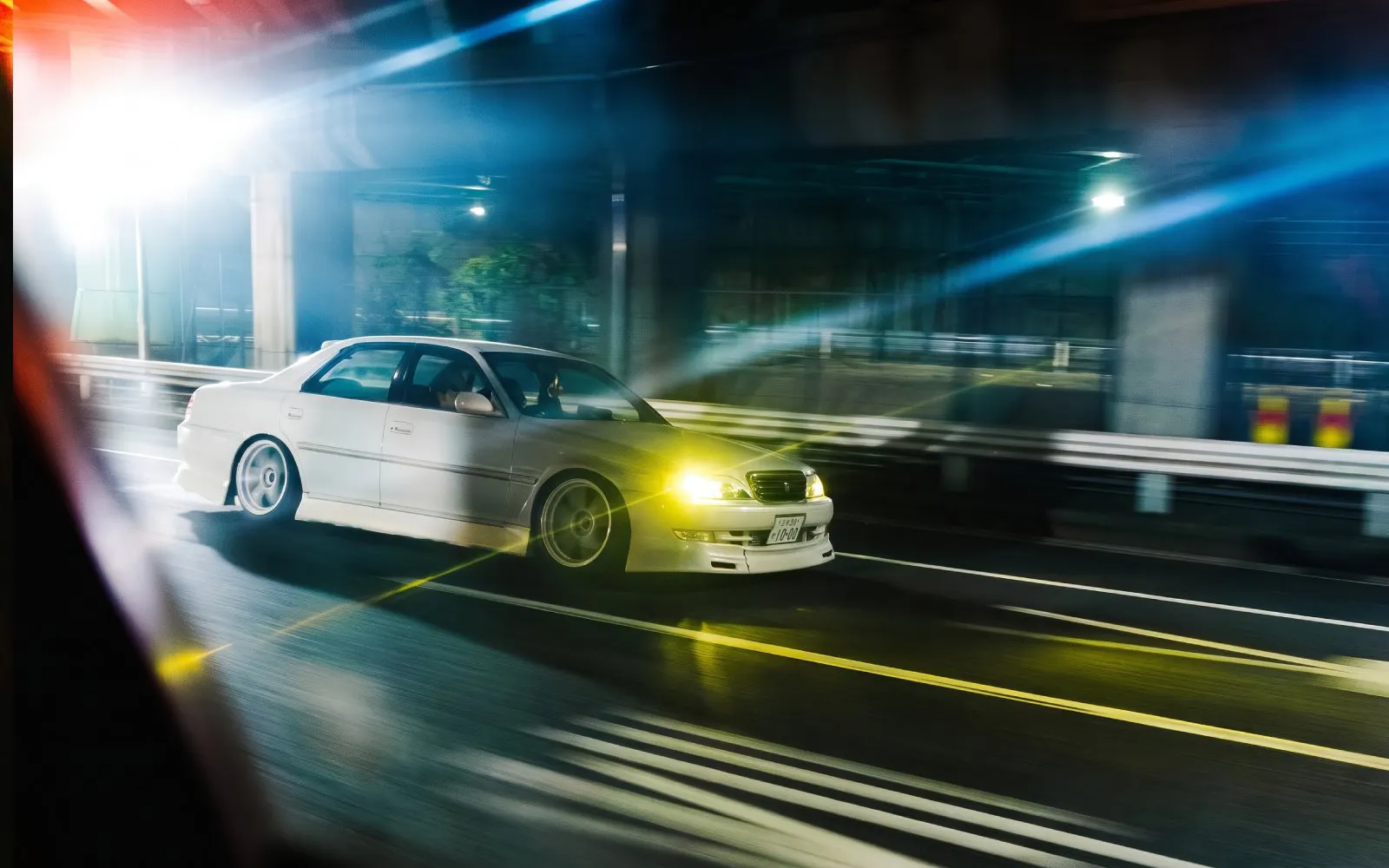 Car drifting on Tokyo highway at night during Fast and Furious experience.